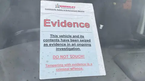 Simon Thake A label on the front window of a van reads: 'Barnsley Council: Evidence. This vehicle and its contents have been seized as evidence in an ongoing investigation. Do Not Touch!"