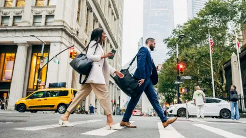 Getty Images Orang -orang berjas melintasi jalan New York