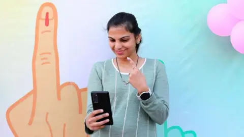 A woman takes a selfie after voting in Delhi election 