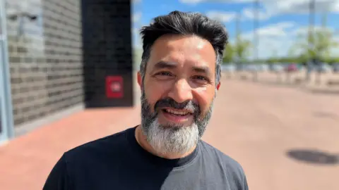 Sam Read/BBC Man with grey t shirt and beard standing outside Stadium MK