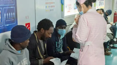 AFP A member of the Chinese military medical team assessing patients on board the Peace Ark in Cape Town, South Africa - 26 August 2024