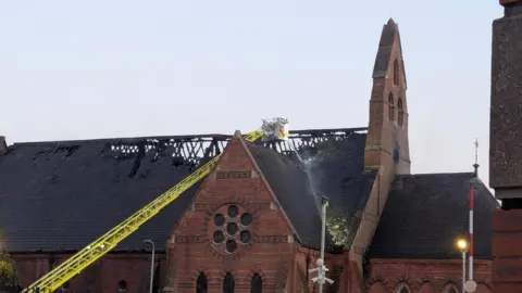 A hose being used on the roof of a church
