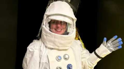 Woman in a white spacesuit and helmet. 