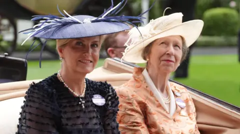 PA Media Sophie, the Duchess of Edinburgh and Anne, the Princess Royal, wearing blue and white hats respectively and wearing a blue dress and orange dress respectively.
