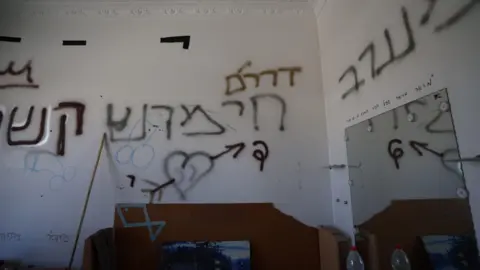 'Israeli forces took over my home and then they set it on fire' Graffit on walls inside an apartment includes lewd images of penises
