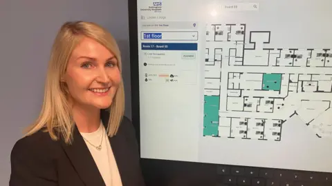 Gerente do Linden Lodge Ward, Sarah Davies, com um mapa digital da unidade para ver quartos e recursos reserváveis
