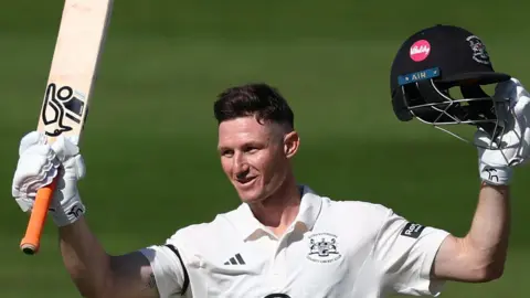 Cameron Bancroft raises his bat and helmet to the crowd