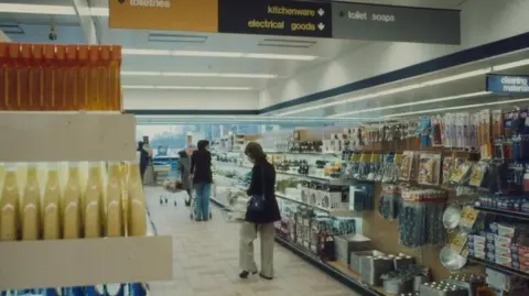 The Sainsbury Archive An interior shot of Sainsbury's, Cambridge, in about 1975. It shows women in an aisle and on their right are piles of kitchenware and electrical goods