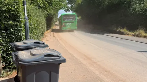 Dust billowing in the air on Radbourne Lane in Derby as a bus passes by