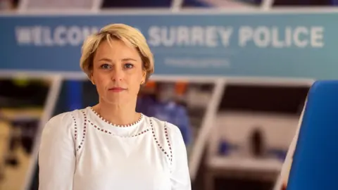 Office of the Police and Crime Commissioner for Surrey A woman with short blonde, wearing a white shirt, looking at the camera. 