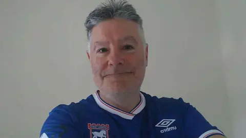 Supplied A selfie style image of Tim Kenny. He is wearing a blue Ipswich Town top and looking into the camera.