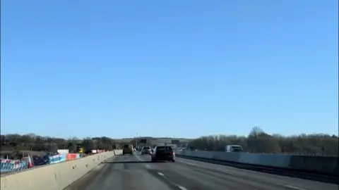 A motorway with cars and a blue sky.