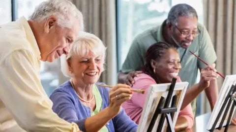 Getty Images Two couples smiling and painting