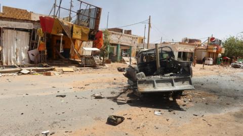 A damaged car and houses in Omdurman, March 2024