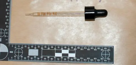 Metropolitan police to dispens the liquid with a black top with a clear pipette with a clear pipette. A black and white ruler is painted for the scale