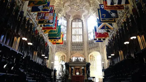 Getty Images Lady Chapel in Westminster Abbey, with a high vaulted ceiling and colourful heraldic flags 