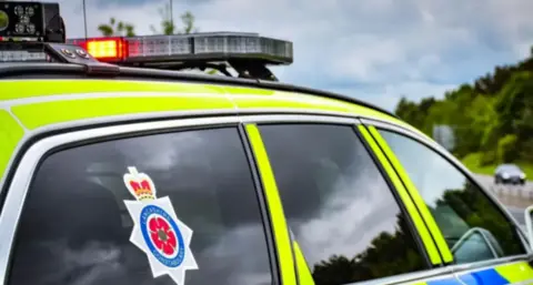 Lancashire Police Library image of a Lancashire Constabulary police car, marked in fluorescent yellow and blue checks.
