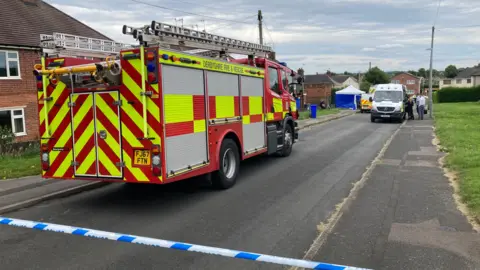 A police cordon with emergence services working on a street in Chesterfield