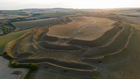 Finnbarr Webster/Getty Images An aerial view of Maiden Castle Iron Age hill fort, location of the Dorset Sunflower Trail, on August 13, 2022 in Dorchester. 