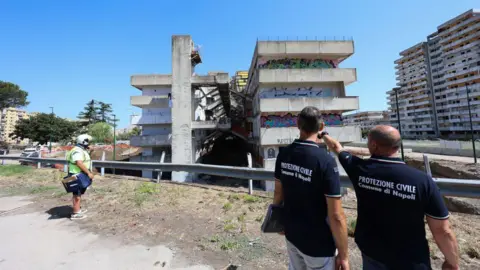  Two men from the Civil Protection in front of the building in the Scampia district of Naples