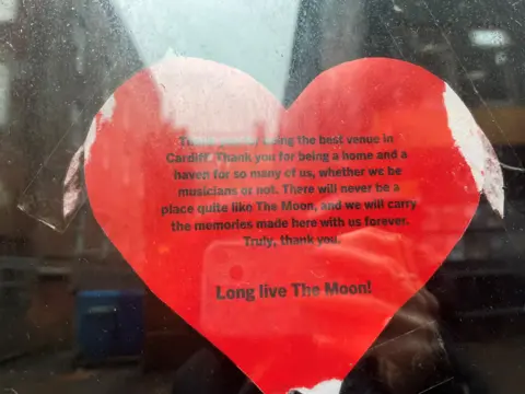 A heart shaped note stuck to the door of the Moon, thanking staff for their support of grassroots venues. At the end of the note, in bold font, it reads 'Long Live The Moon!'.