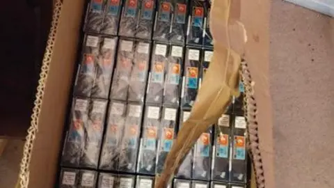 Cheshire Police A carboard box that has been ripped open and is full of cigarettes