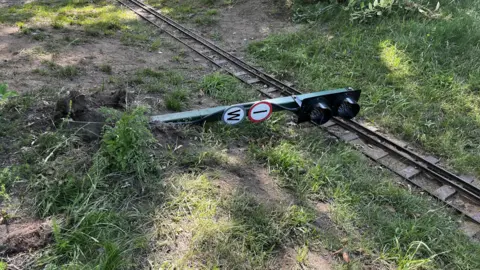 Jack Maclean/BBC A signal has been ripped from the ground and lays across the miniature train track.