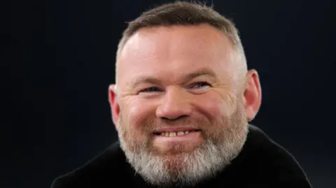 Wayne Rooney smiling against a black background