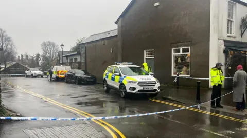 Police officers, vehicles and tape in Chapel Street, Llandaff, on Christmas Eve 2023