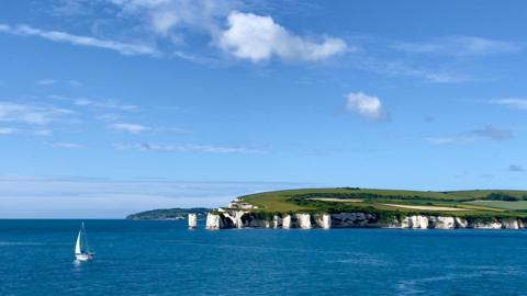 WEDNESDAY - Old Harry Rocks with a white sailing boat in Studland Bay