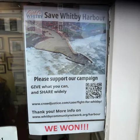 Carla Fowler/BBC A poster for the Fight4Whitby Save Whitby Harbour campaign in a shop window