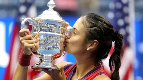 Emma Raducanu kisses the US Open trophy 