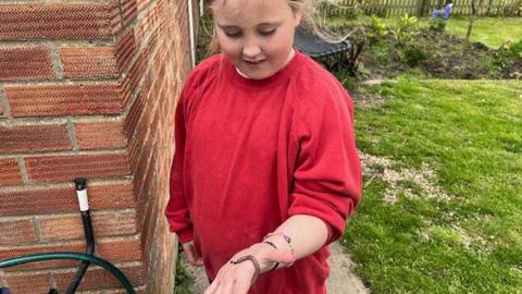 Child holding a millipede