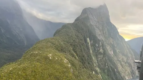 Southern District Police An area of Mitre Peak mountain in New Zealand, pictured from a helicopter. The terrain is steep and rocky.