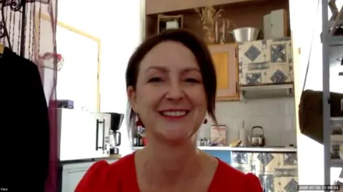 A woman with brown hair smiles at the camera