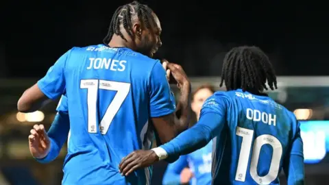 Getty Images Ricky-Jade Jones, wearing a blue number seven shirt, celebrates with team-mate Abraham Odoh, wearing the number 10 shirt.