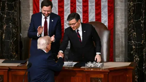 Getty Images Trump seen shaking hands with Vice-President Vance and Speaker of the House Johnson during his March 2025 speech to Congress