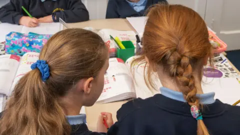 North Yorkshire Council Two schoolgirls sitting at a table look at a book
