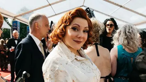 Getty Images Sophie Willan in a cream silky dress on the red carpet ahead of her Bafta win