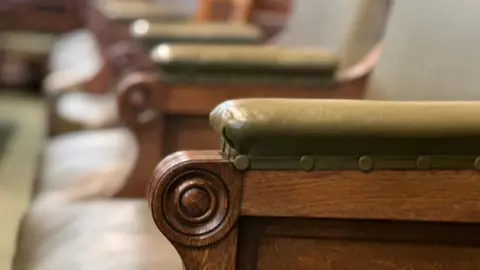 Una fila de asientos en los Cayos, revestidos de cuero verde.