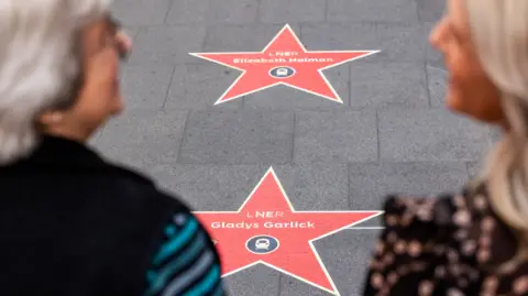 LNER Looking over the shoulders of two women who are standing by two LNER stars dedicated to Elizabeth Holman and Gladys Garlick