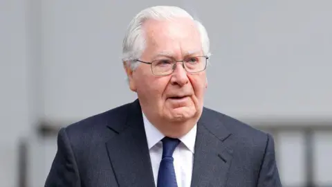 Getty Images Lord Mervyn King in a dark grey suit and blue tie