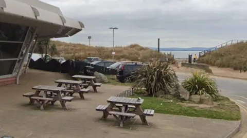 Google Four picnic benches outside Crosby Leisure Centre next to the sand dunes at Crosby Beach.