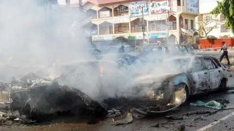Getty Images Smoke rising after bomb exploded on some vehicles in Abuja in 2014