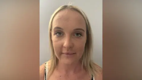 A police custody photo of Emily Drury - a young woman with blonde hair.