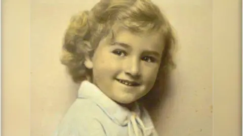 Hedi Argent A colourised photograph of a young Hedi Argent, smiling slightly and looking at the camera.