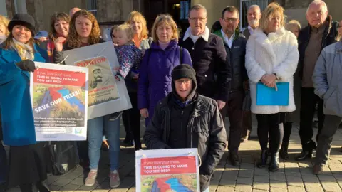 Protestors holding signs outside Macclesfield Town Hall.