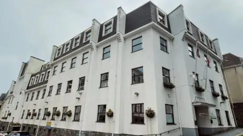 BBC Edward T Wheadon House in St Peter Port, Guernsey. A four-story white office building.