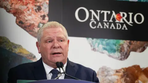 Image of Doug Ford speaking at a podium with the 'Ontario' logo behind him