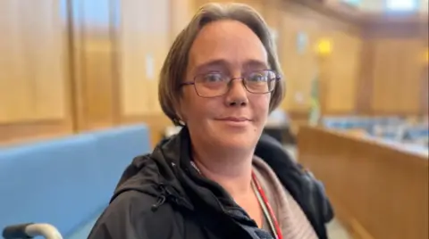 A woman with glasses and short brown hair